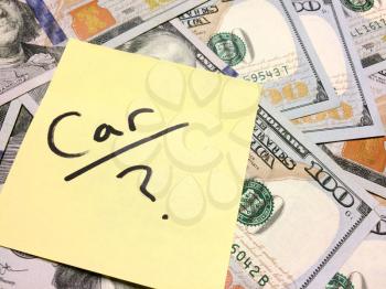 American cash money and yellow sticky note with text Car with question mark in black color aerial view