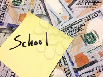 American cash money and yellow sticky note with text School in black color aerial view