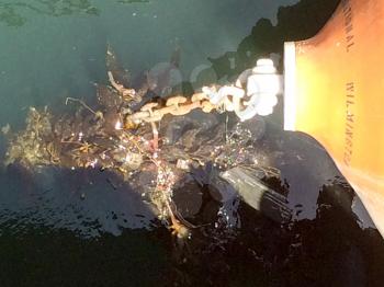 Dirty Ocean sea trash pollution wrapped on anchor chain on USS Iowa naval warship destroyer battleship