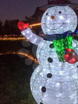 snowman christmas decoration with lights in yard at night time