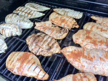 chicken fillets on barbecue grill with sauce and lines
