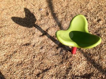 empty playground seat made of green plastic with shadow lonely lines design element background