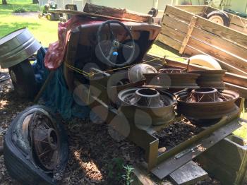 rusty antique ford car in backyard with spoked wheels junkyard
