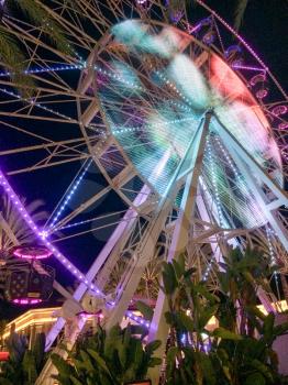 Ferris wheel illuminated at night colorful light motion scene