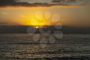 sun breaking through the clouds above the horizon on Tenerife