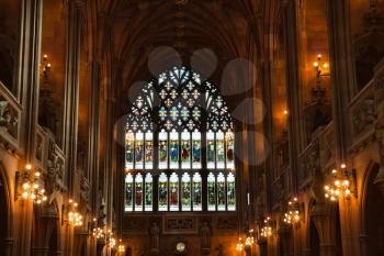 Manchester, UK: 20 October 2019: The John Rylands Library Historic Reading Room showing stained glass window and candelabra
