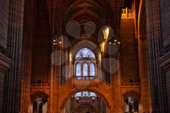 Liverpool, UK - 19 October 2019: Interior of Cathedral Church of Christ showing a stained glass window and nave