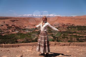 Road trip around Morocco, girl posing in front of the panoramic view of the High Atlas Mountains, North Africa