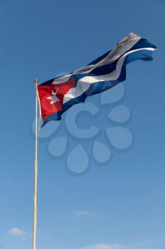 Cuban flag waiving in front of the blue sky