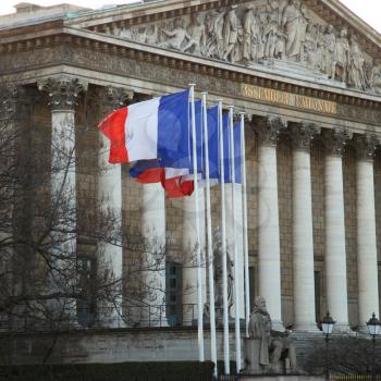 Assemble national is the lower house of the bicameral Parliament of France under the Fifth Republic.  French flags floatings in front of the assemble.
