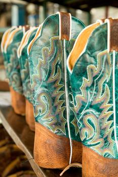 Turquoise cowboy boots on a shelves to be completed