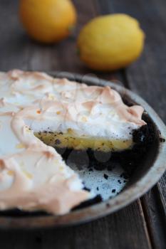 Lemon pie with meringue on a rustic wood table