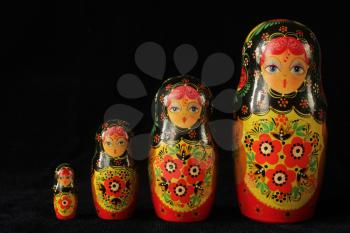 Traditional russian dolls in a row on a black background