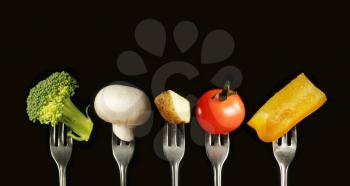 Variation of fresh vegetables on a black background, broccoli, mushroom, potato, tomato and yellow capsicum.