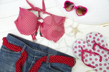Ready to go on the beach with a red top bikini, jeans, sandals, hat and heart shape sunglasses