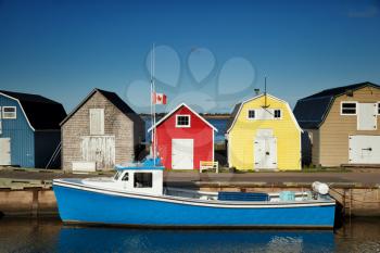 Blue fishing boat in front of oysters barns in New London, Prince Edward island also called PEI