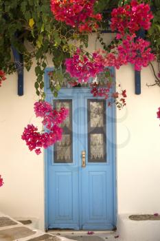 Bougainvillea under a bright blue door in Naxos, Greece