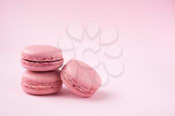 Stack of french traditional pink macarons on pink background