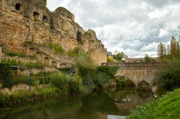 Stone bridge across the Alzette river with a cloudy sky in Luxembourg in Europe