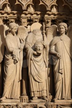 Details of three statues on a the front of the Cathedral Notre Dame de Paris, in France