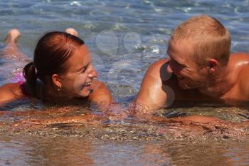 Royalty Free Photo of a Couple Laying in Water Talking