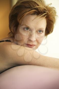 Royalty Free Photo of a Woman Draped Over a Sofa by the Window