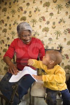 Portrait of African American grandmother with grandson coloring.