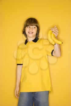 Royalty Free Photo of a Boy Holding a Bunch of Bananas