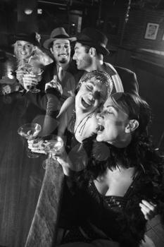 Royalty Free Photo of a Group of Males and Females Sitting at a Bar Laughing