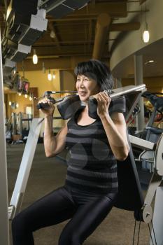 Royalty Free Photo of an Older Woman Using an Exercise Machine at a Gym