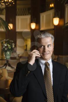 Royalty Free Photo of a Businessman Talking on Cellphone in a Hotel Lobby