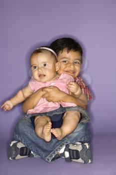 Royalty Free Photo of a Boy Holding His Baby Sister