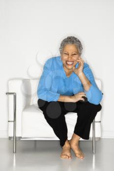 African American mature adult female sitting on chair.