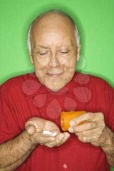 Royalty Free Photo of a Man Emptying Pill Bottles into Hand
