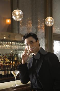 Royalty Free Photo of a Male Standing at a Bar With a Cocktail
