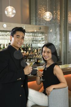 Royalty Free Photo of a Man and Woman Drinking Cocktails at a Bar