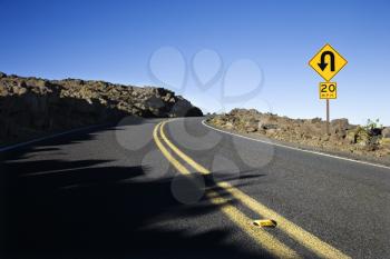 Royalty Free Photo of a Road and Curve in a Road Sign in Haleakala National Park, Maui, Hawaii