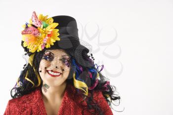 Caucasian woman in unique makeup and clothing standing against white background.