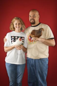 Royalty Free Photo of a Man and Woman Holding Chickens