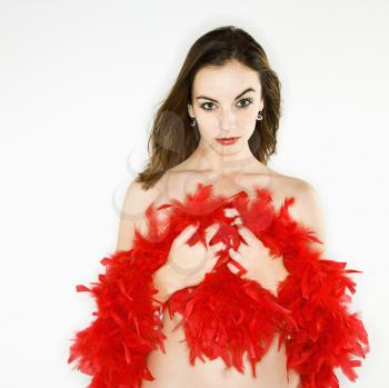 Pretty bare Caucasian  woman holding red feather boa and looking at viewer. 