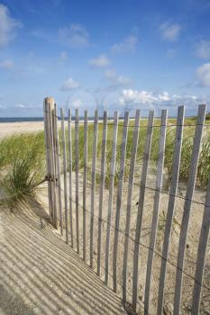 Royalty Free Photo of a Weathered Wooden Fence on a Sand Dune