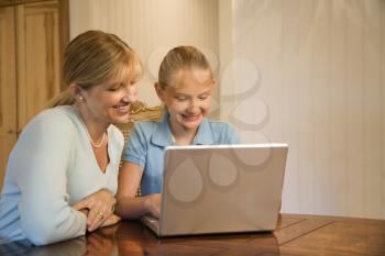 Royalty Free Photo of a Woman and Preteen Girl Using a Laptop Computer