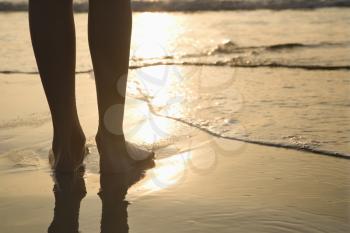 Royalty Free Photo of a Person Standing Barefoot on the Beach