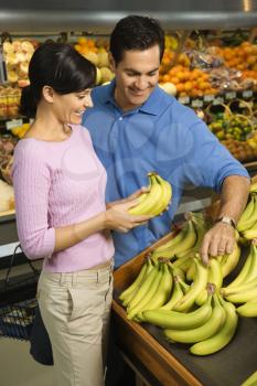 Royalty Free Photo of a Couple Grocery Shopping For Bananas