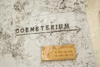 Royalty Free Photo of a Sign With an Arrow Directing Towards Coemeterium in Rome, Italy