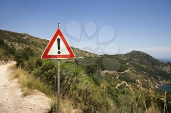 Royalty Free Photo of a Caution Sign on a Coastal Dirt Road