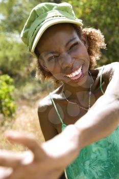 Royalty Free Photo of a Female Smiling With Her Hand Reaching Out Towards the Camera