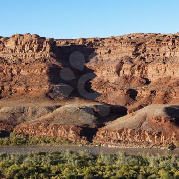 Royalty Free Photo of a Small River Running Along Rocky Desert Cliffs in Utah