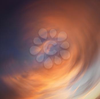 Royalty Free Photo of Spiral Orange Clouds in the Sky at Sunset
