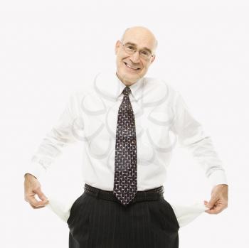 Caucasian middle-aged businessman pulling empty pockets out standing against white background.